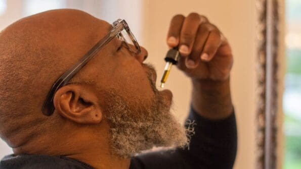 picture of an older man taking cbd drops under the tongue