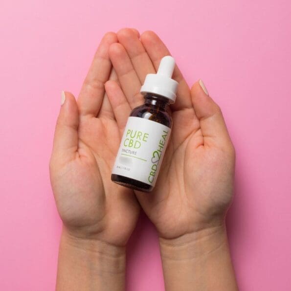 hands holding a dropper bottle of pure cbd oil tincture 5000mg