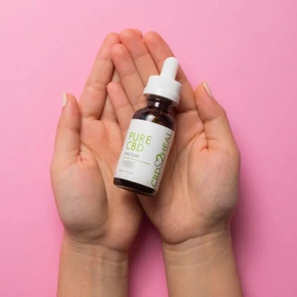 hands holding a dropper bottle of pure cbd oil tincture 5000mg