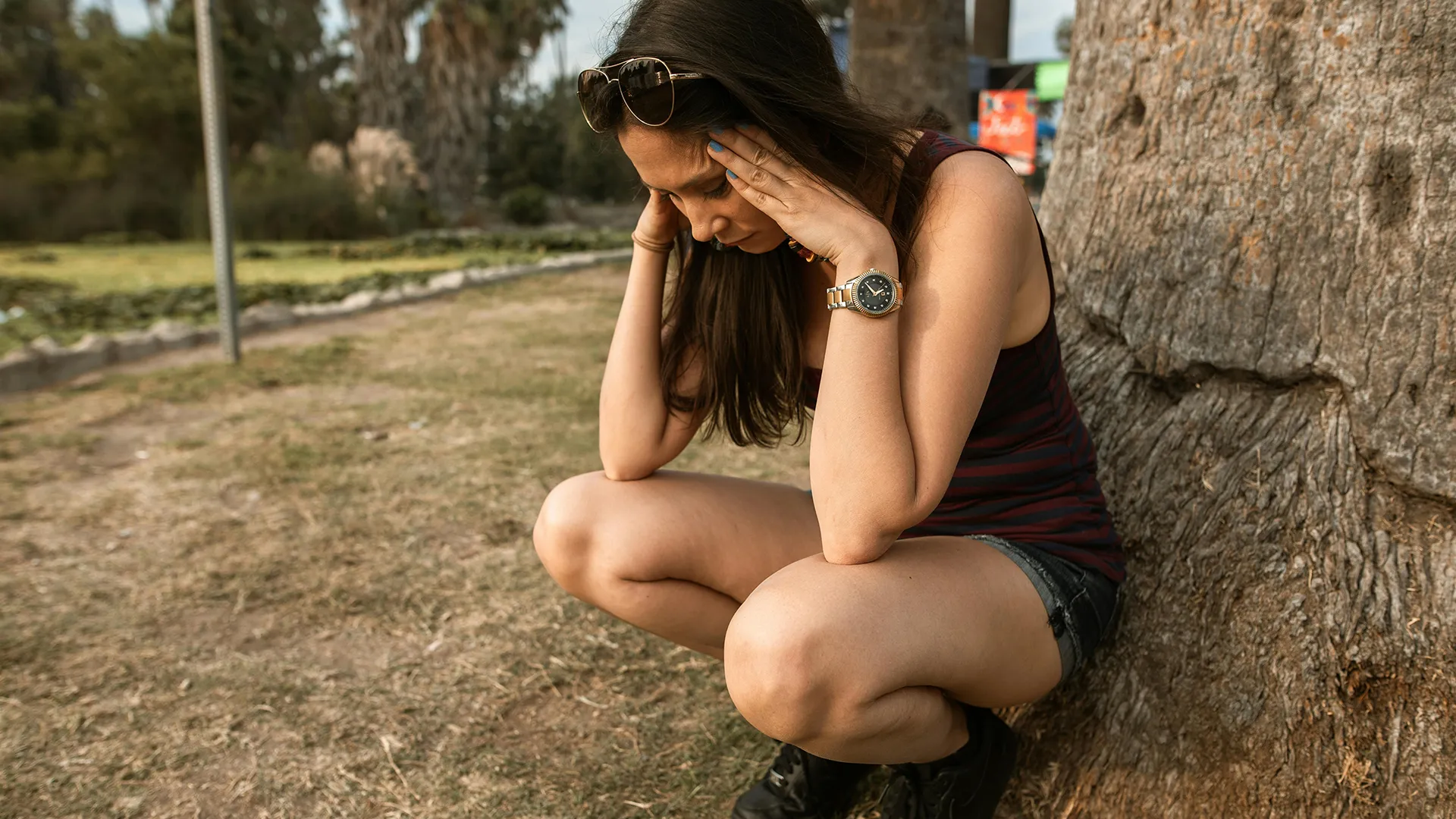 picture of a woman outdoors crouched having an anxiety attack